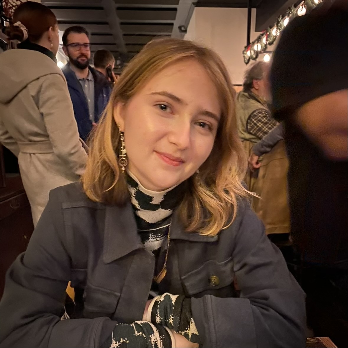 Blond girl smiling with arms crossed.