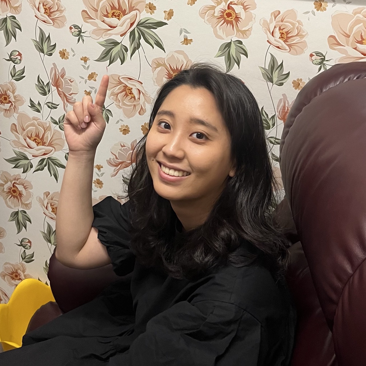 Smiling girl pointing her finger up.