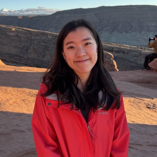 Smiling woman wearing a red jacket at Arches national park